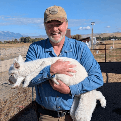 Trainer Clark holding baby alpaca Skye.